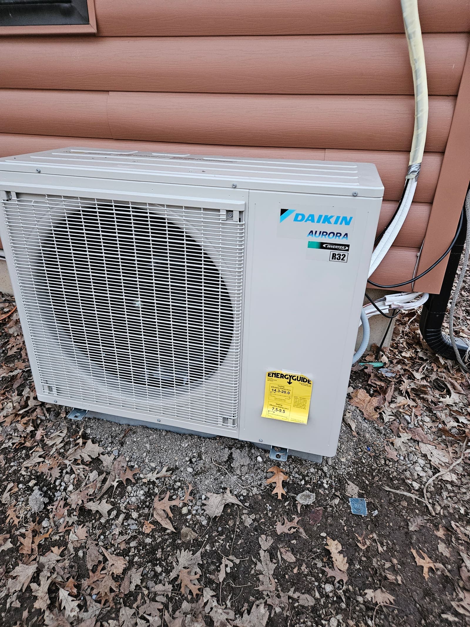 Heat pump condenser mounted on siding